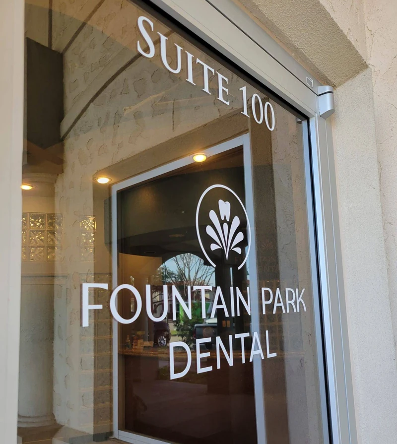 Dentist Flower Mound TX Fountain Park Dental Logo on Front Entrance Window the Fountain Park Dental logo is seen on the front entrance window of the clinic