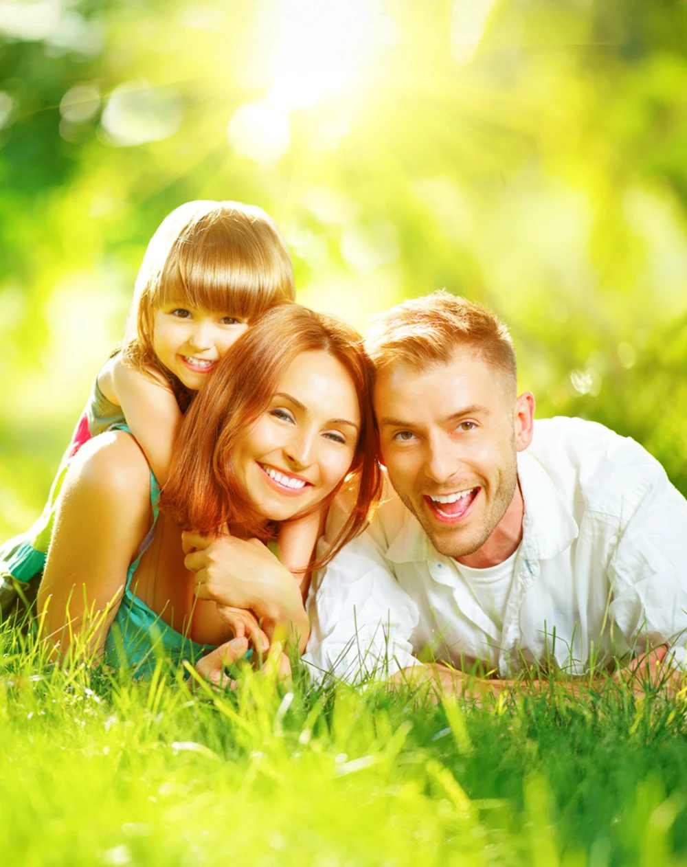 A happy, smiling family in a grassy field